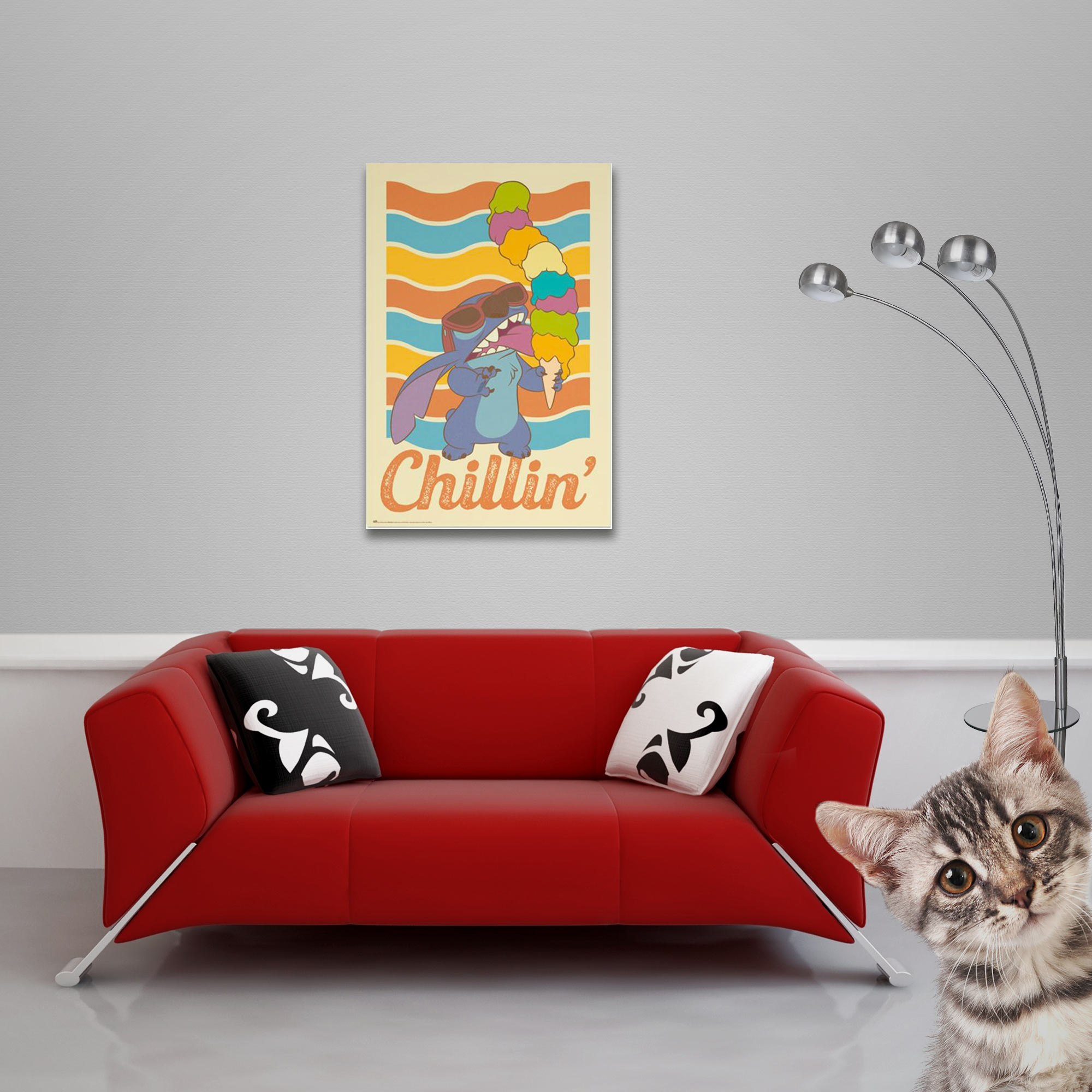 Ein Poster von Stitch, der Eis isst, an einer Wand über einem roten Sofa. Eine Katze blickt in die Kamera.