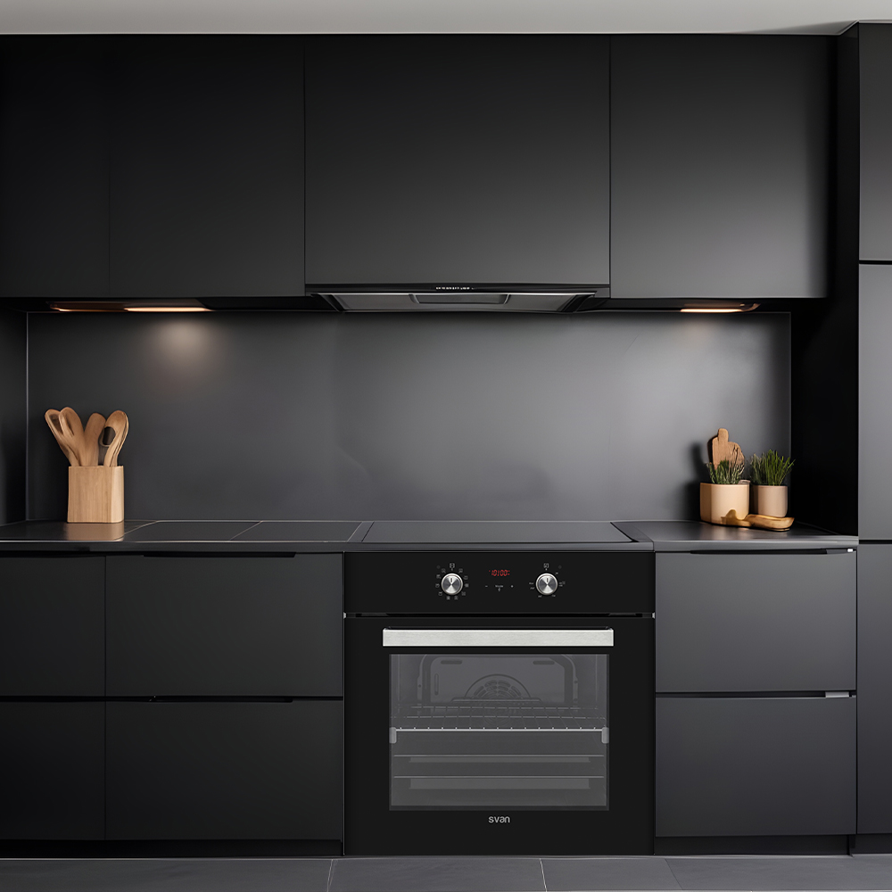 Cocina negra moderna con armarios, horno y campana extractora negros. Utensilios de madera y plantas.