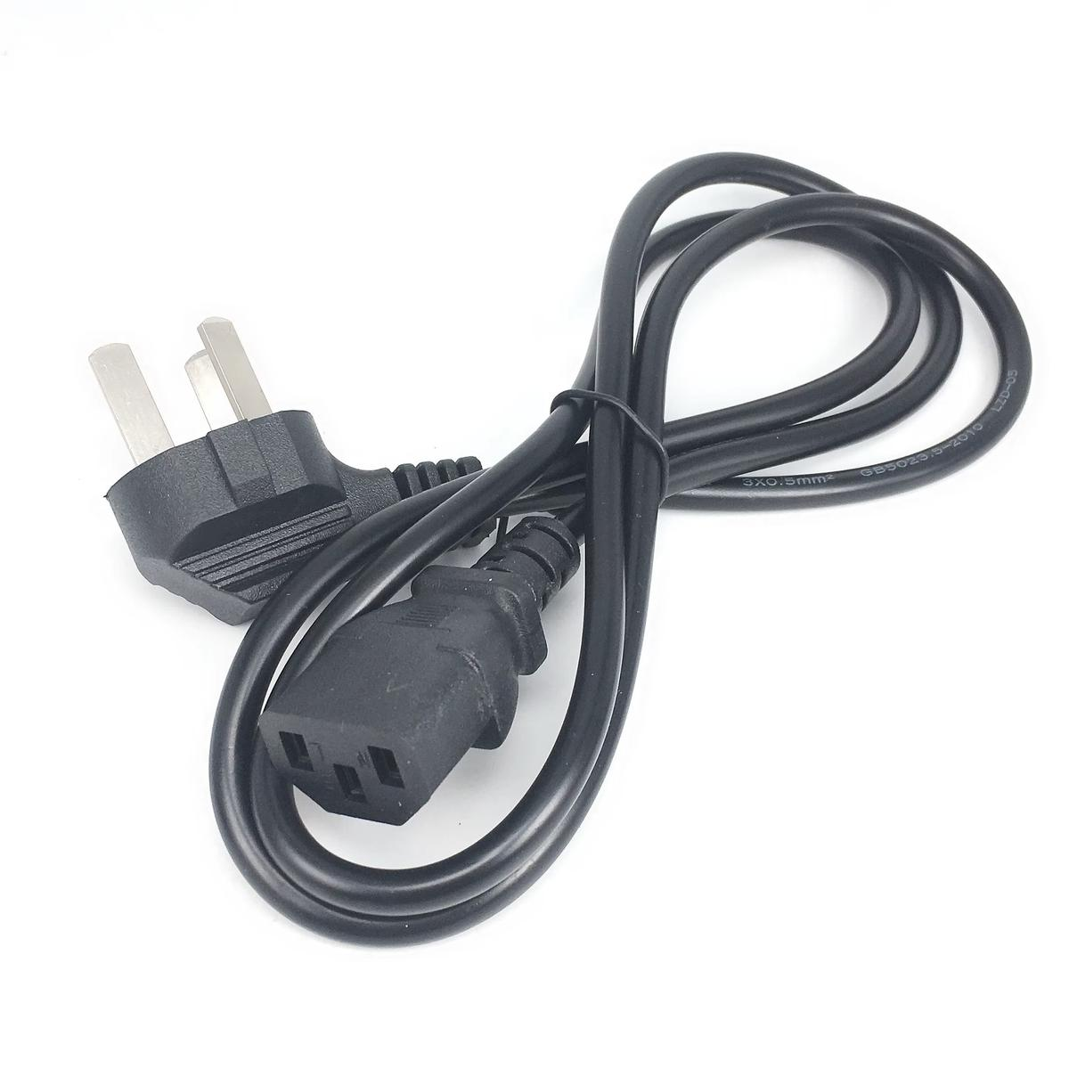 Ein schwarzes Netzkabel mit UK-Stecker und C13-Stecker, das auf einer weißen Oberfläche liegt.