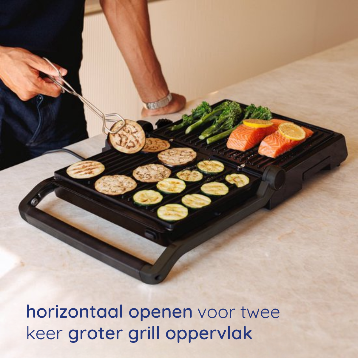 A person uses tongs to remove food from a black grill. Other items are on the grill. Kitchen setting.