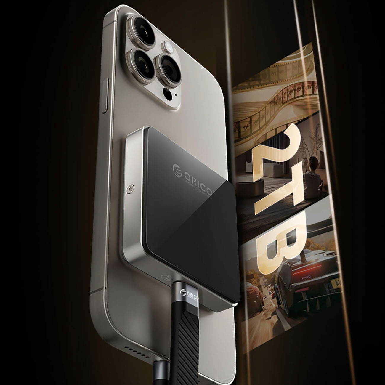 Czarna ładowarka przymocowana do srebrnego telefonu. Telefon jest przymocowany do wyświetlacza z tekstem 2TB.