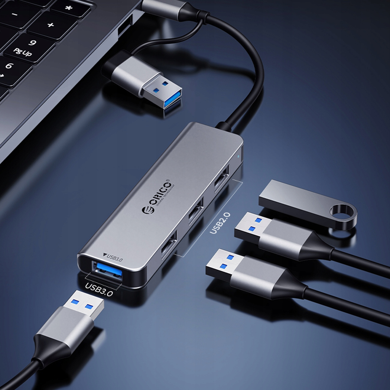 Srebrny hub USB podłączony do laptopa. Kilka urządzeń USB podłączonych.