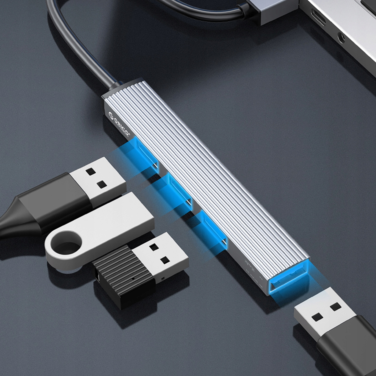 Hub USB podłączony do laptopa z wieloma dyskami USB.
