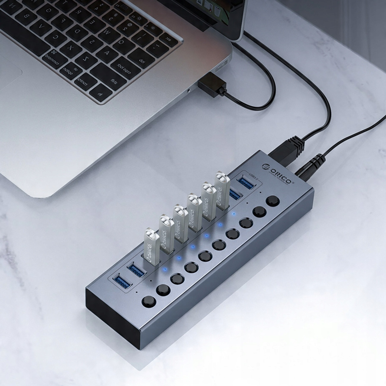 Hub USB collegato a un laptop con più chiavette USB inserite.