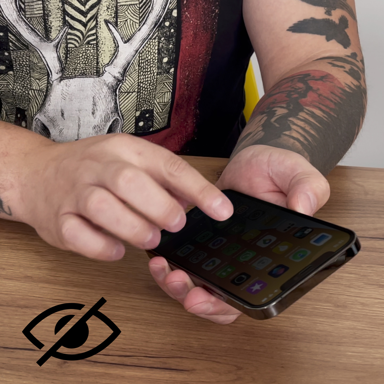 Osoba trzymająca telefon. Ekran jest czarny z widocznym przekreślonym symbolem oka.