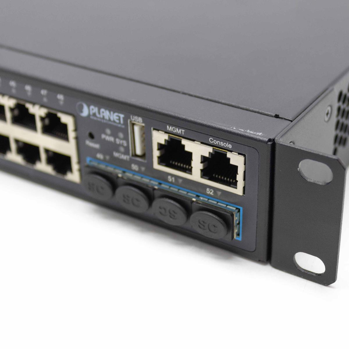 Switch di rete nero con porte etichettate. Ha porte USB e console a destra.