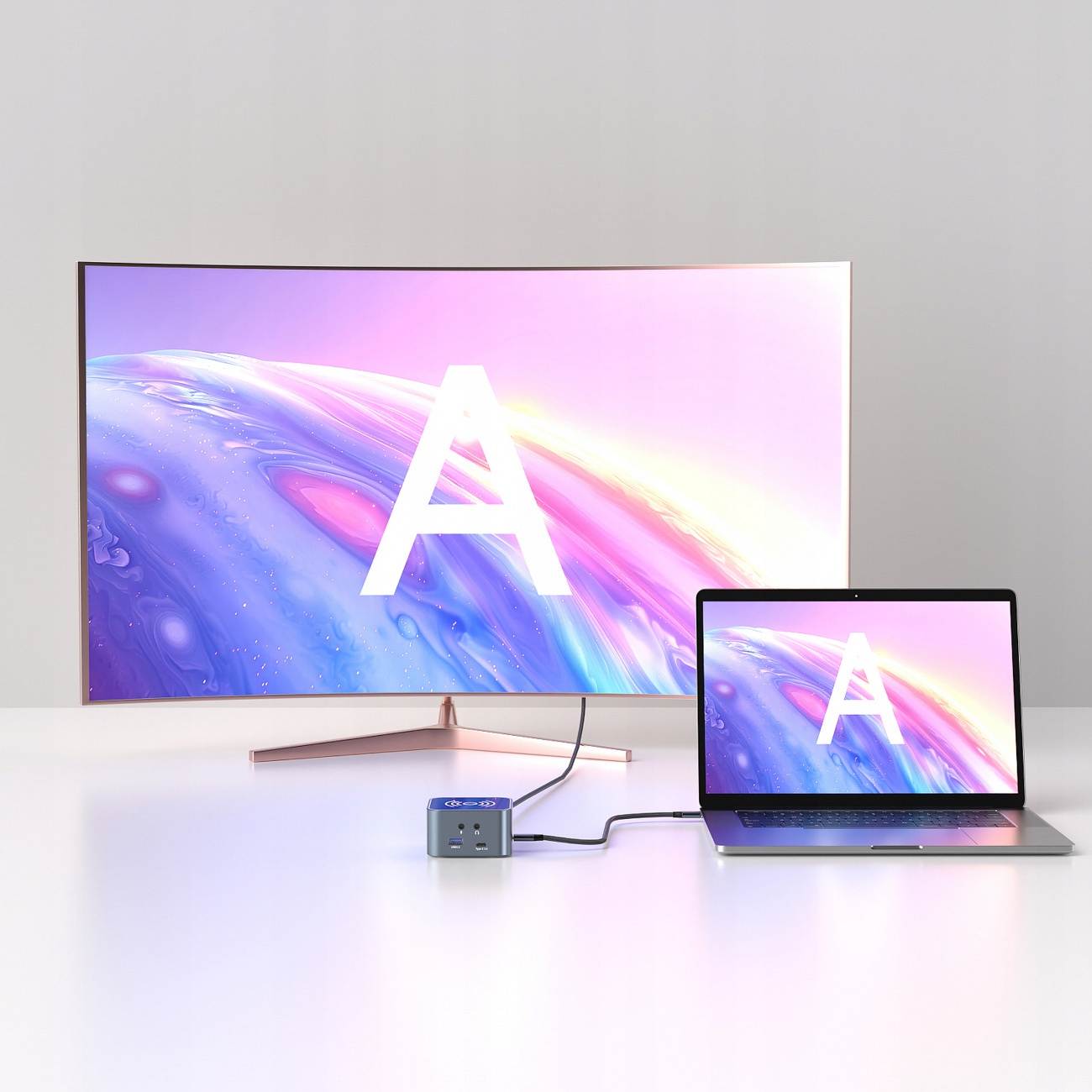 Laptop i monitor wyświetlający literę 'A' podłączone do ładowarki.