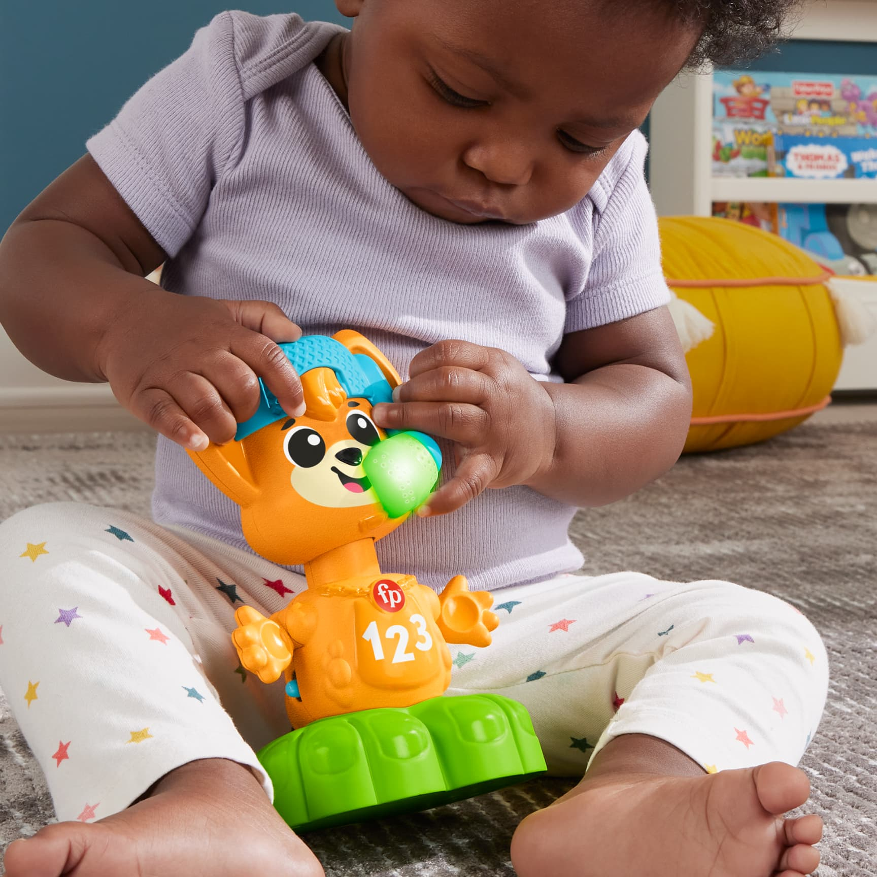 Ein Baby interagiert mit einem Spielzeugbären mit blauem Hut und den Zahlen 123 auf der Brust.