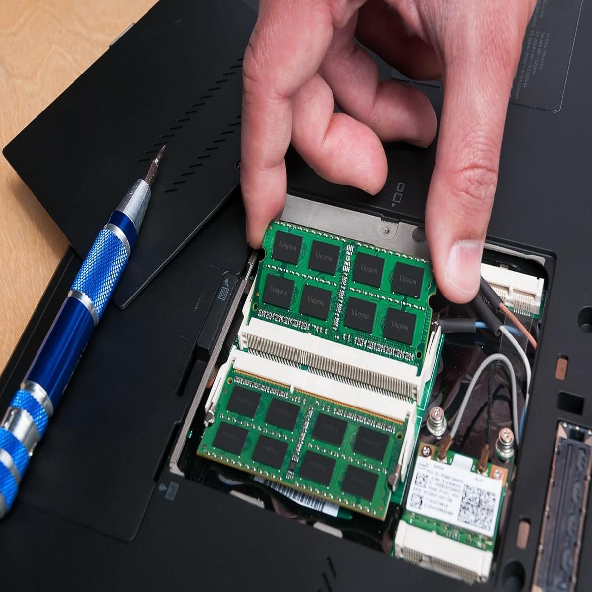 Una mano che installa moduli RAM in un laptop.