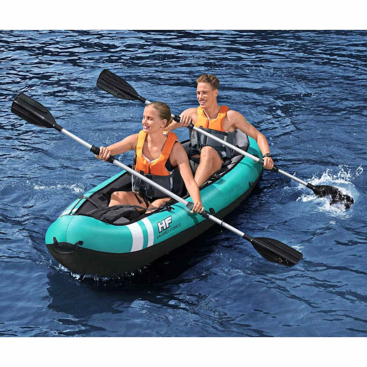Deux personnes dans un kayak turquoise sur l'eau, en train de pagayer. Elles portent des gilets de sauvetage oranges.
