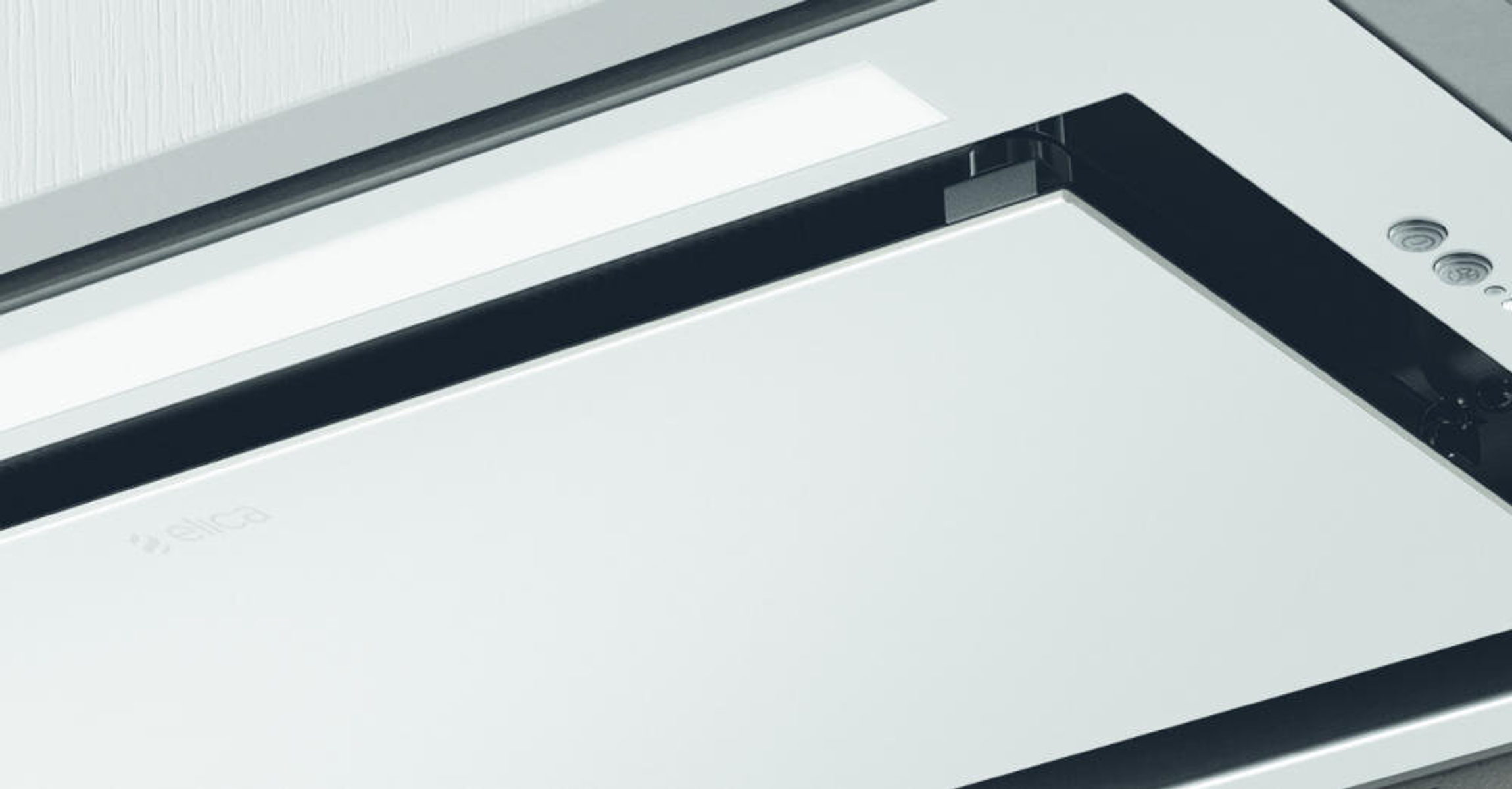 Zbliżenie białego okapu. Świeci światło, widoczne logo Elica.