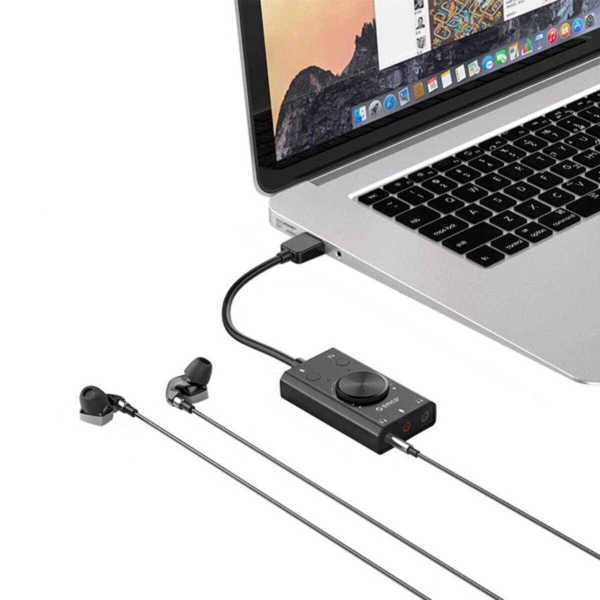 Un'interfaccia audio nera collegata a un laptop tramite USB. Sono collegate anche cuffie e auricolari.