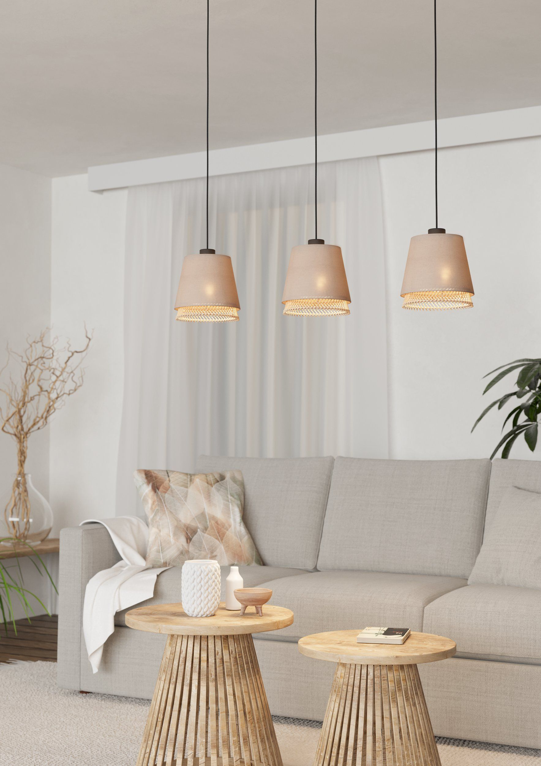 Innenaufnahme mit drei Pendelleuchten mit beigen Schirmen, über Holztischen und einem Sofa.
