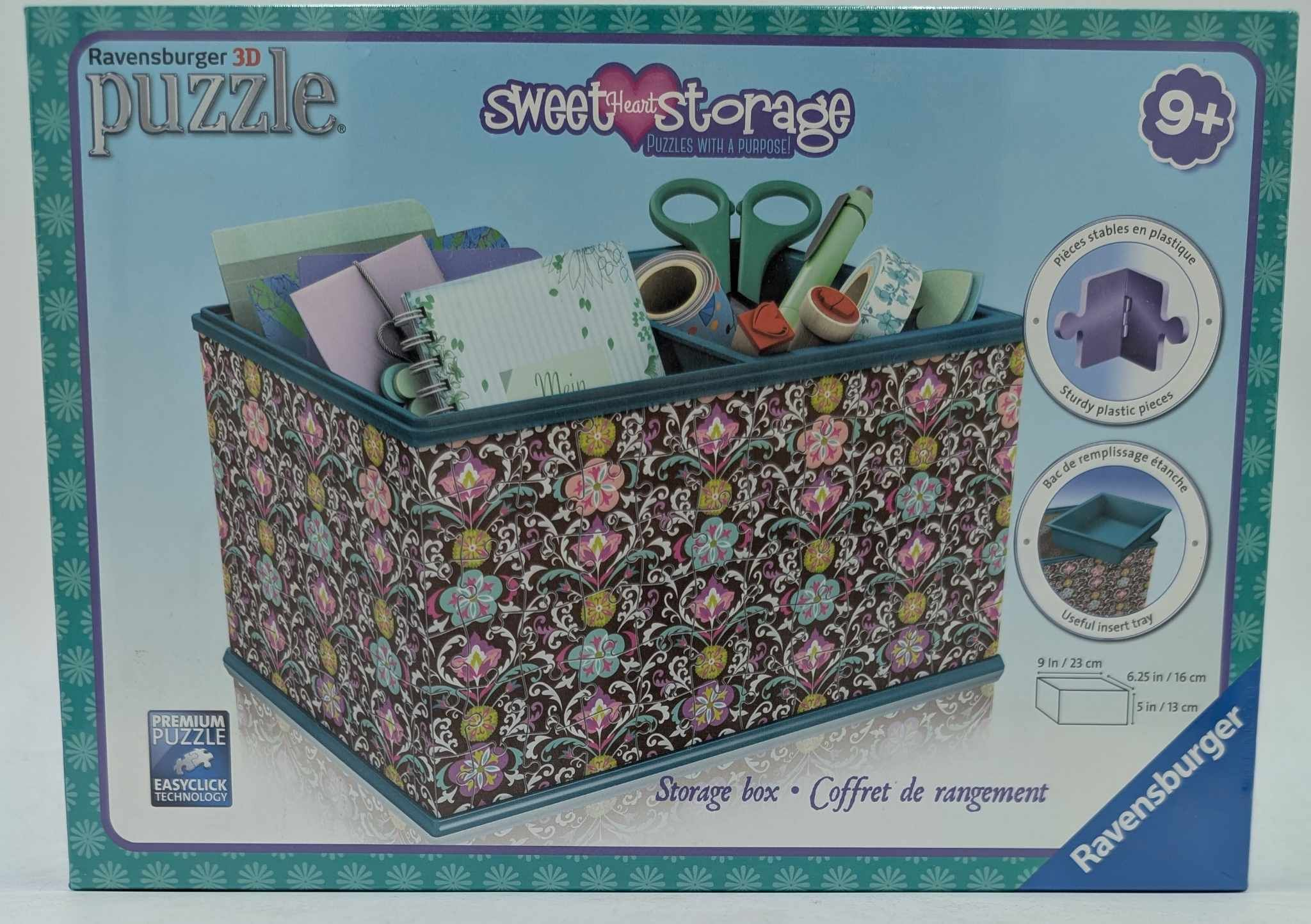 Eine Aufbewahrungsbox mit Blumenmuster und verschiedenen Bastelmaterialien, darunter Schere und Klebeband.