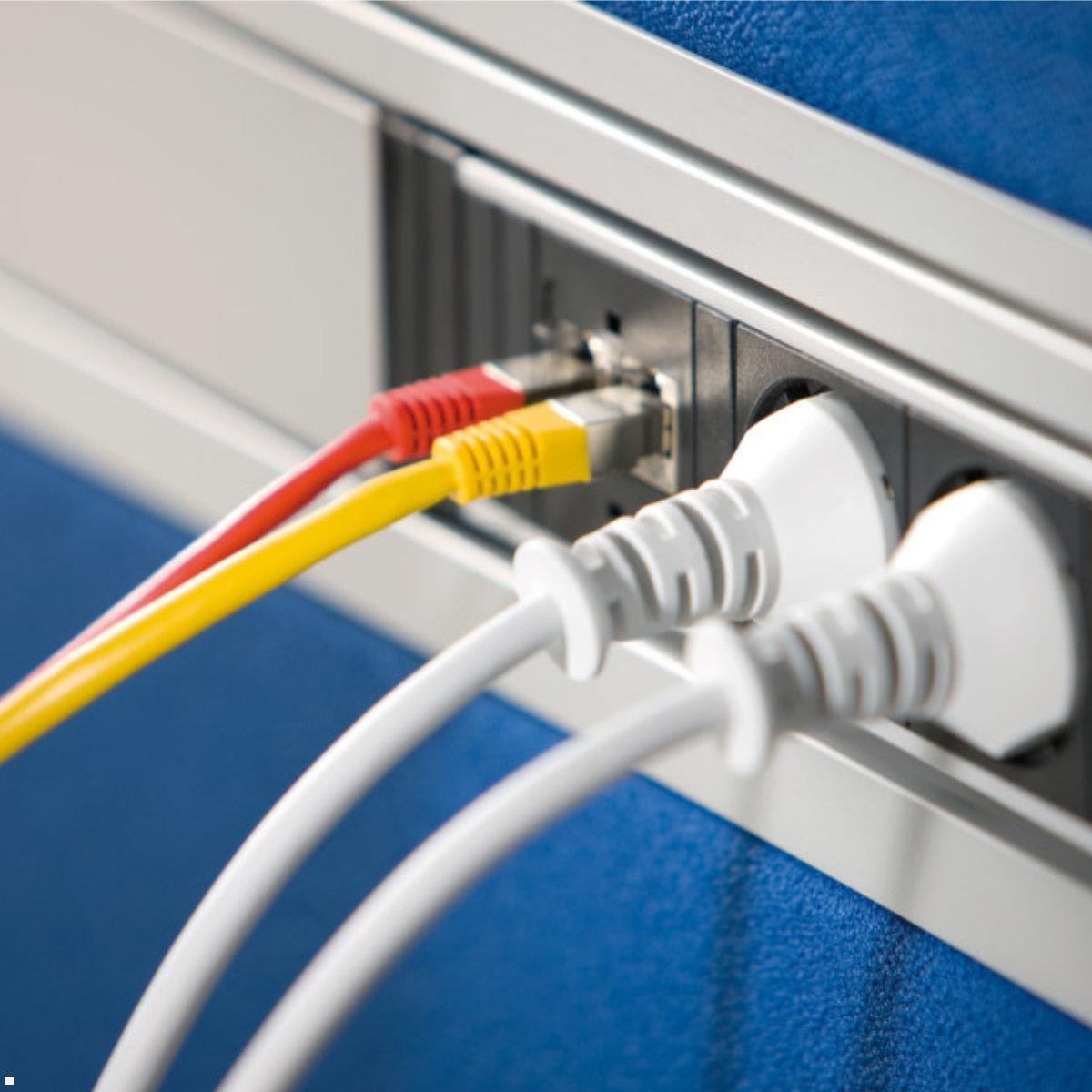 Zbliżenie kabli zasilających podłączonych do gniazda ściennego. Trzy kable: czerwony, żółty i biały.