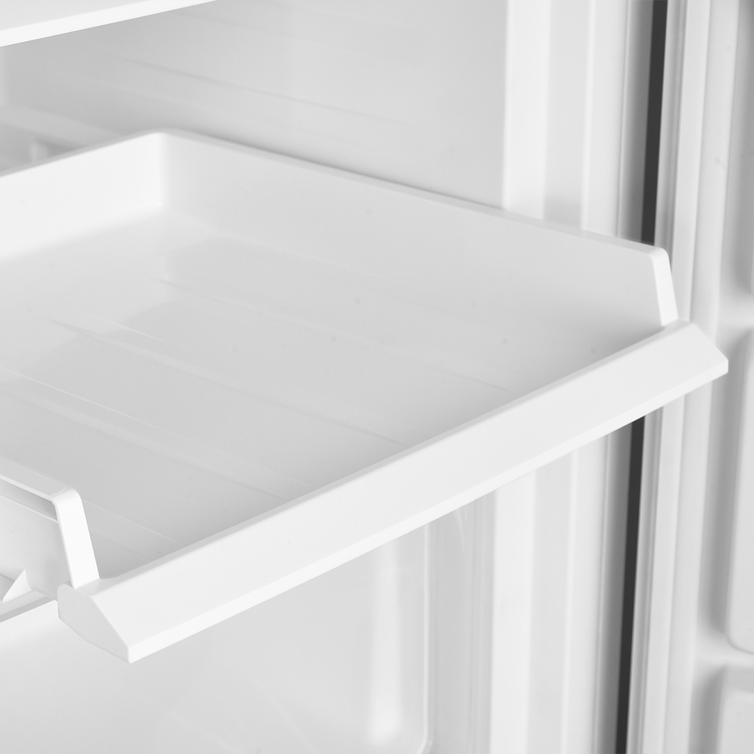 Primer plano de una bandeja blanca dentro de un frigorífico. La bandeja tiene borde y está vacía.