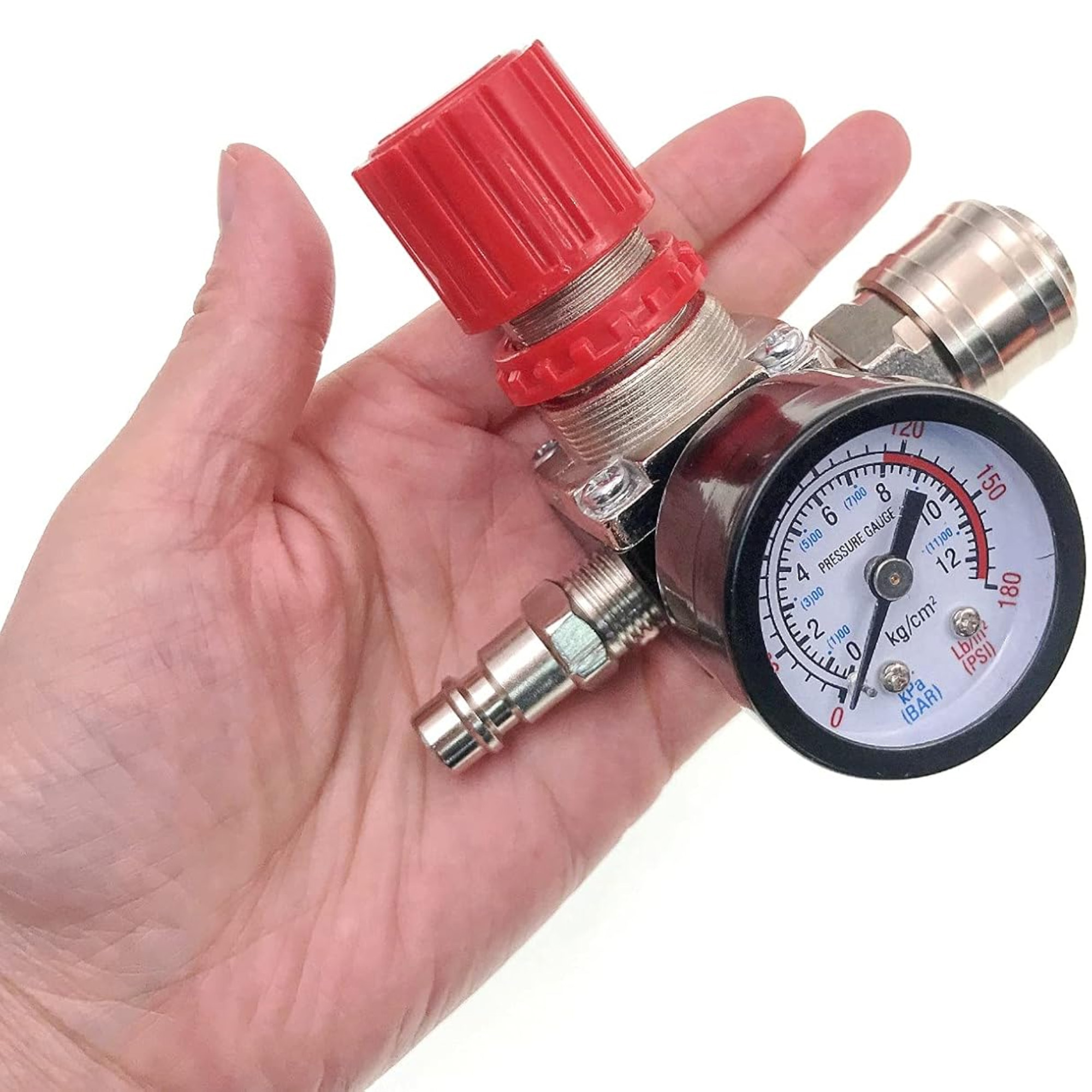Eine Hand, die einen Luftdruckregler hält, mit einem roten Knopf, Manometer und Schnellkupplungen.