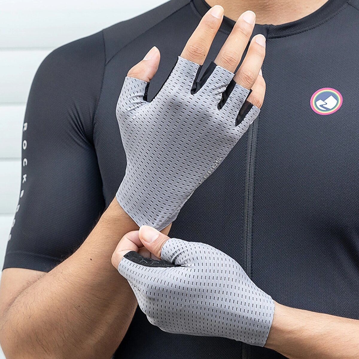 Eine Person, die graue, fingerlose Radhandschuhe trägt.