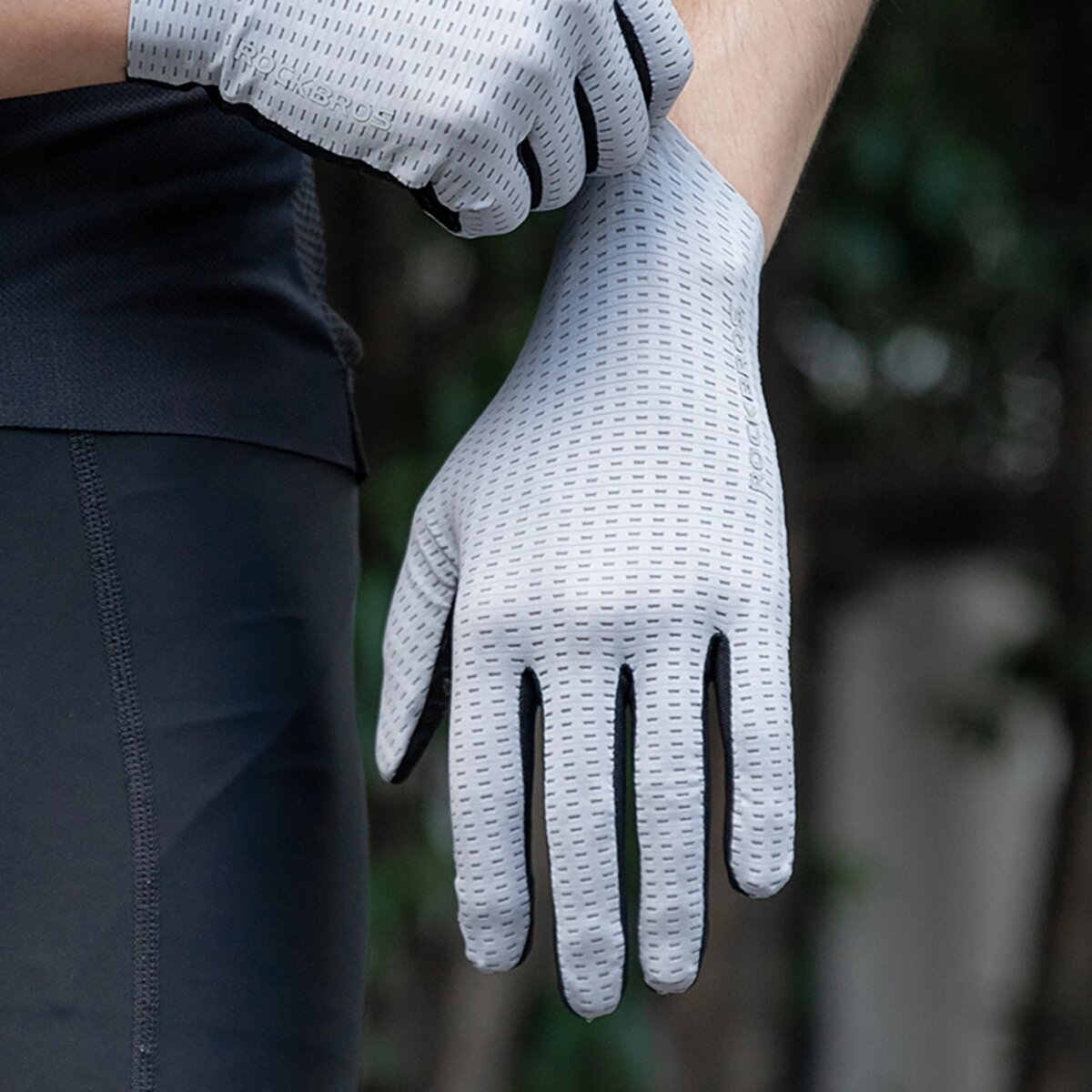 Eine Person, die graue Radhandschuhe trägt.