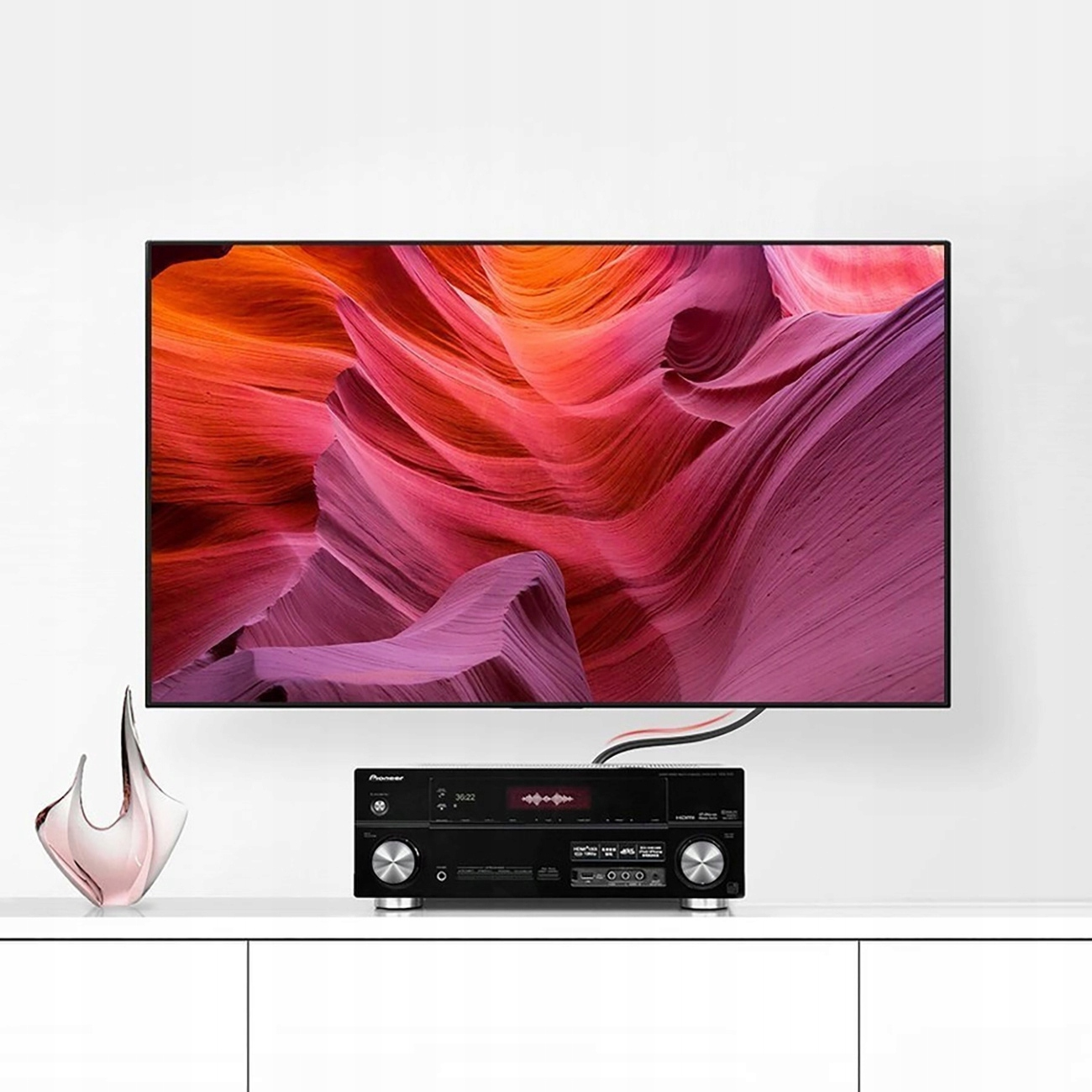 Ekran telewizora wyświetlający krajobraz i czarny odbiornik AV.