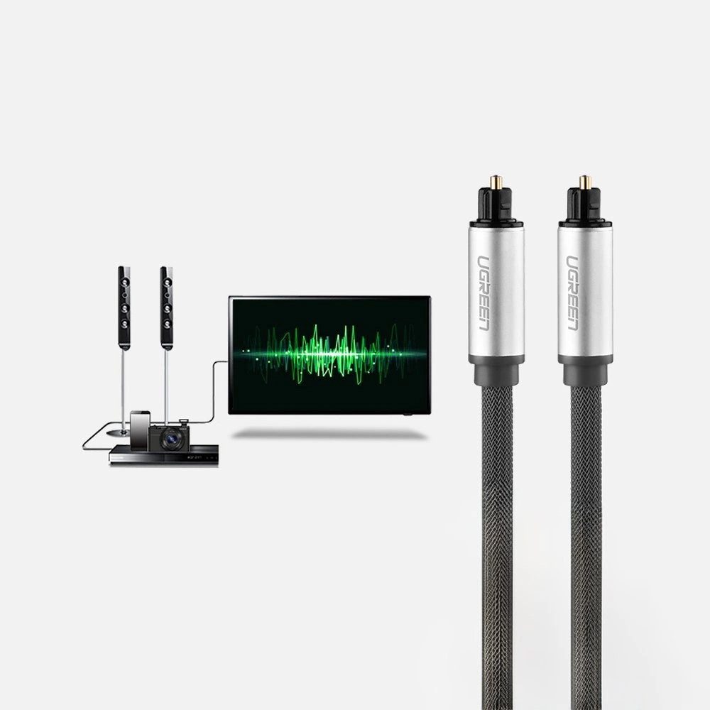 Dwa czarne kable ze srebrnymi końcówkami, telewizor i głośniki na białej powierzchni.