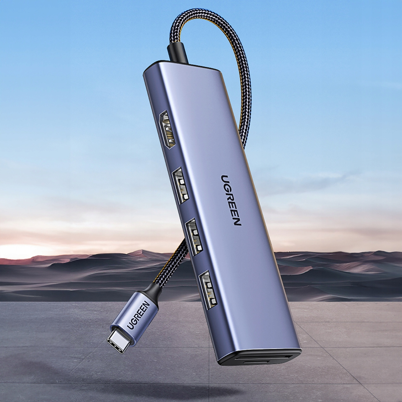 Hub UGREEN z wieloma portami. Jest srebrny i niebieski z plecionym kablem i złączem USB-C.