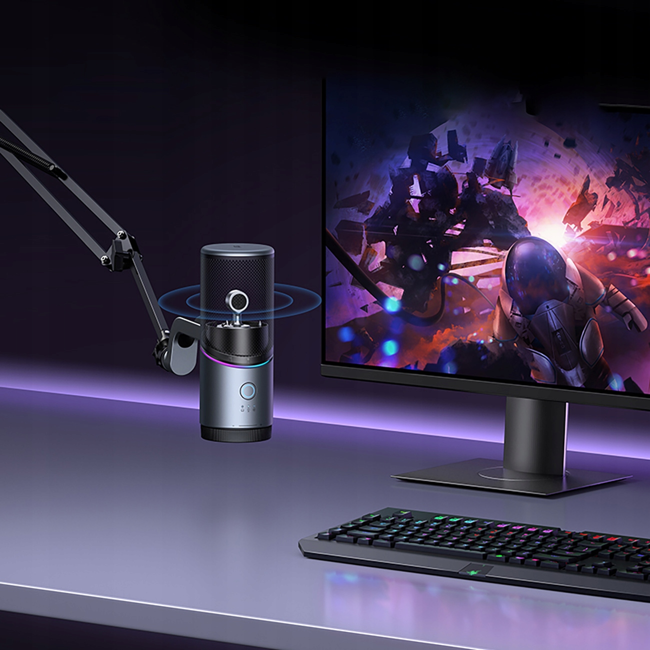 Mikrofon na biurku, podłączony do monitora komputera. Klawiatura jest na pierwszym planie.