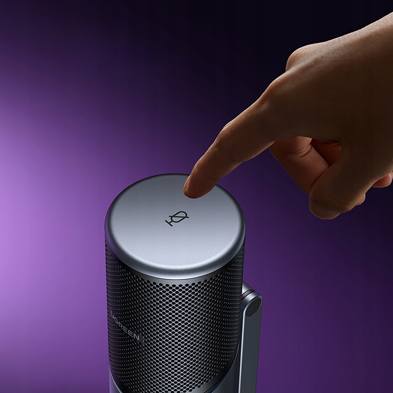 Dłoń naciskająca przycisk na srebrnym mikrofonie na fioletowym tle.