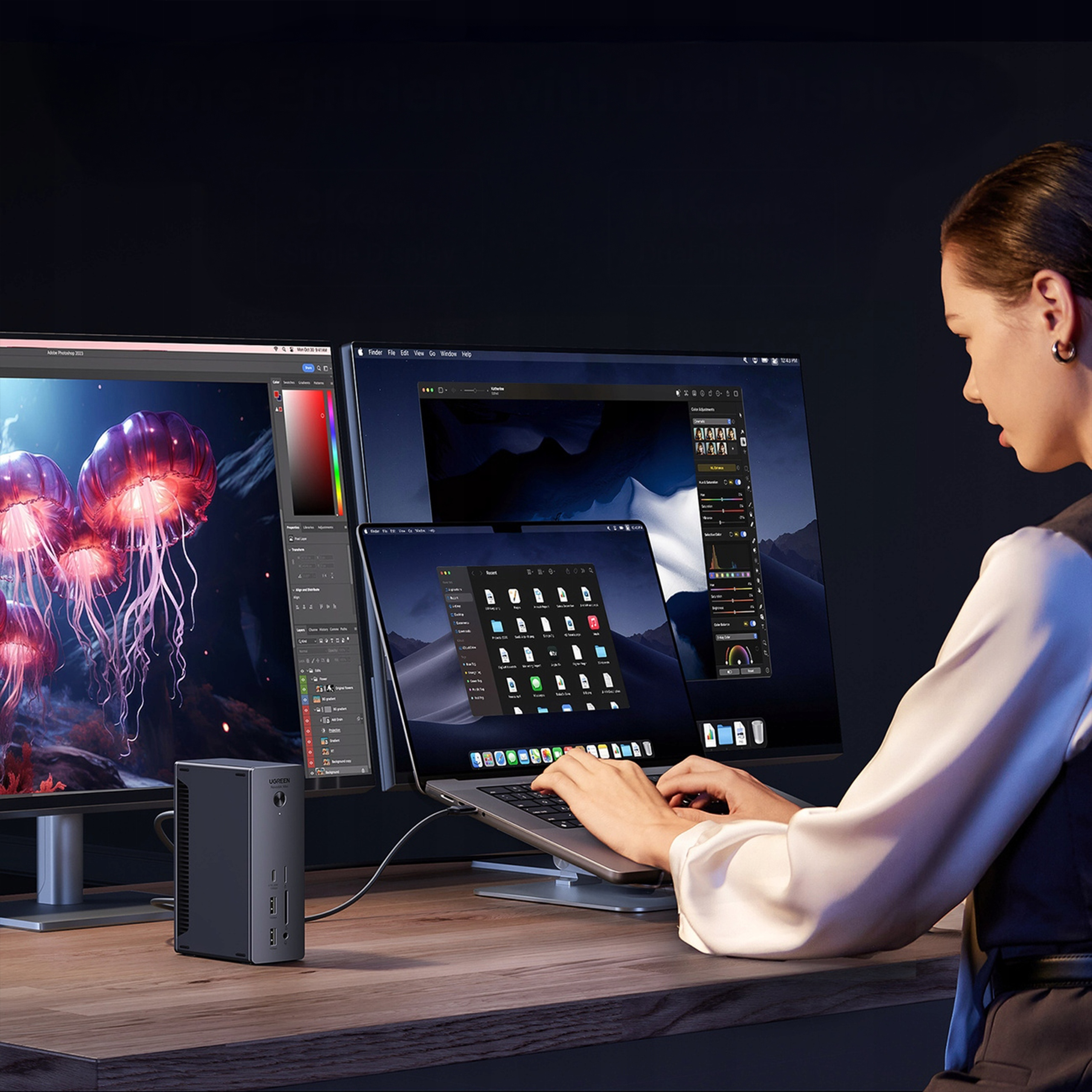 Kobieta używa laptopa podłączonego do dwóch monitorów. Hub na biurku. Meduzy na jednym monitorze.