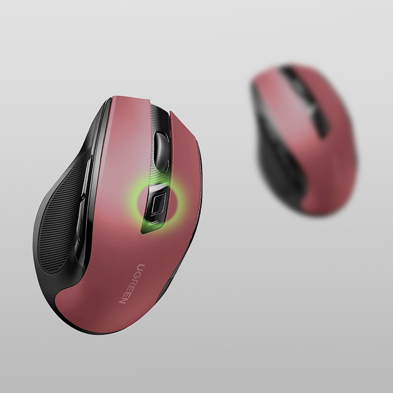 Czerwona i czarna mysz komputerowa z zielonym światłem na przycisku, druga mysz jest rozmyta w tle.