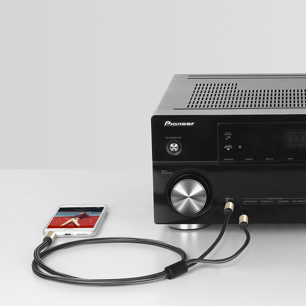 Odbiornik audio Pioneer podłączony do smartfona i głośnika, z kablami.