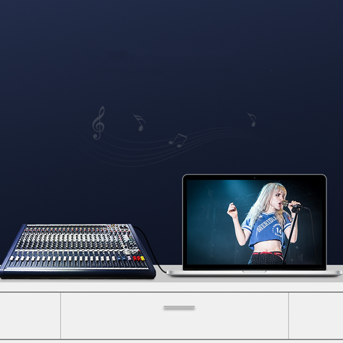 Konsola mikserska podłączona do ekranu laptopa, wyświetlająca występ na żywo z wokalistką.