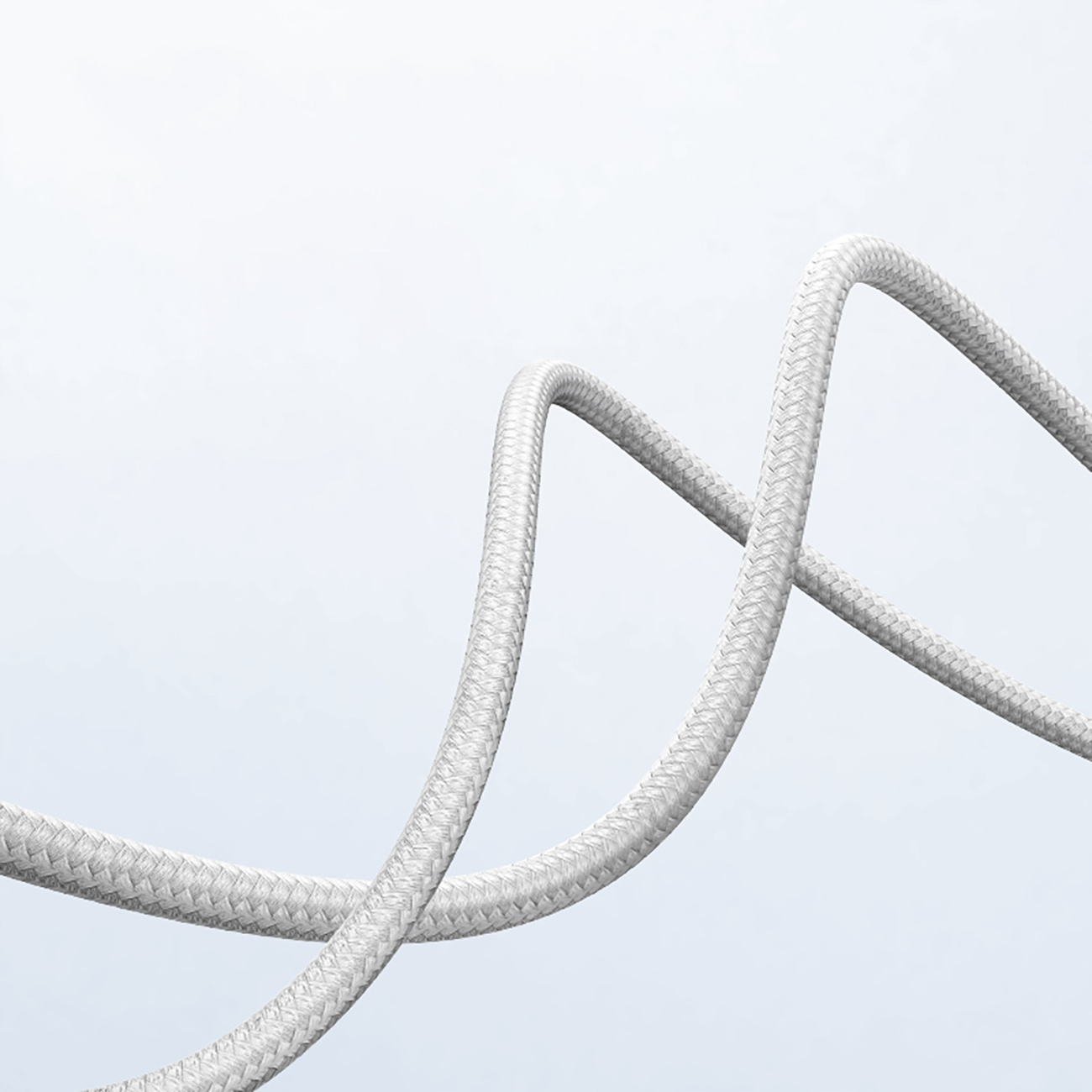 Gevlochten witte kabel, gebogen tegen een witte achtergrond.