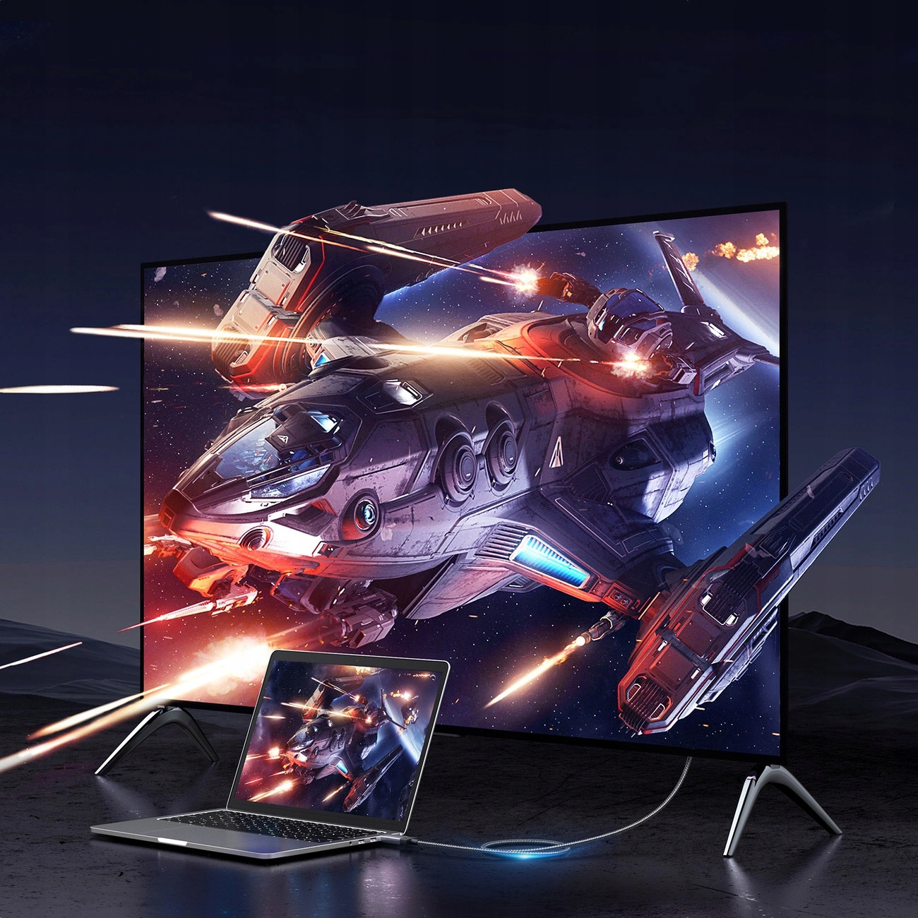 Statek kosmiczny jest na ekranie, a laptop wyświetla ten sam obraz, połączony kablem.