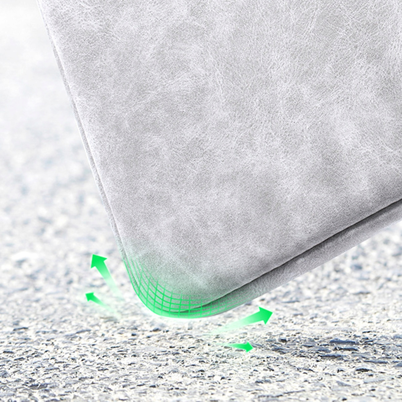 Narożnik szarej powierzchni. Zielone strzałki pokazują odporność na uderzenia. Powierzchnia jest teksturowana, prawdopodobnie materiał ochronny.