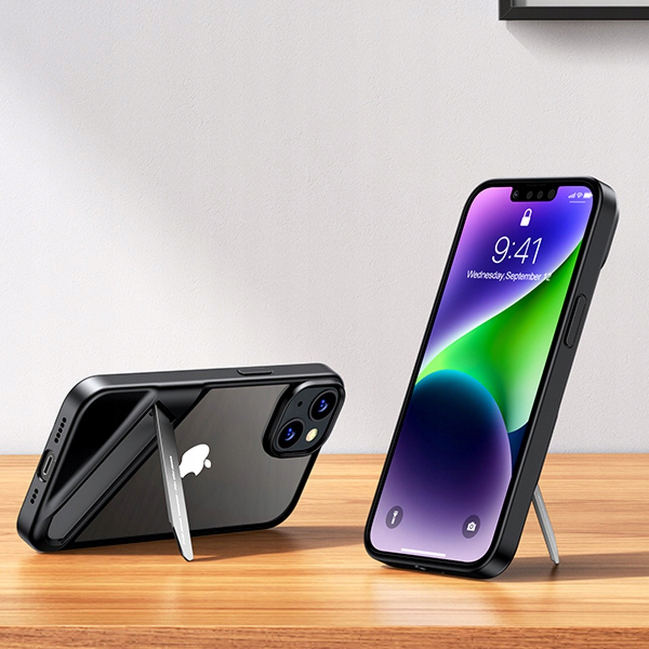 Due telefoni con custodie nere; uno in piedi con schermo verde, l'altro sdraiato, entrambi su una superficie chiara.