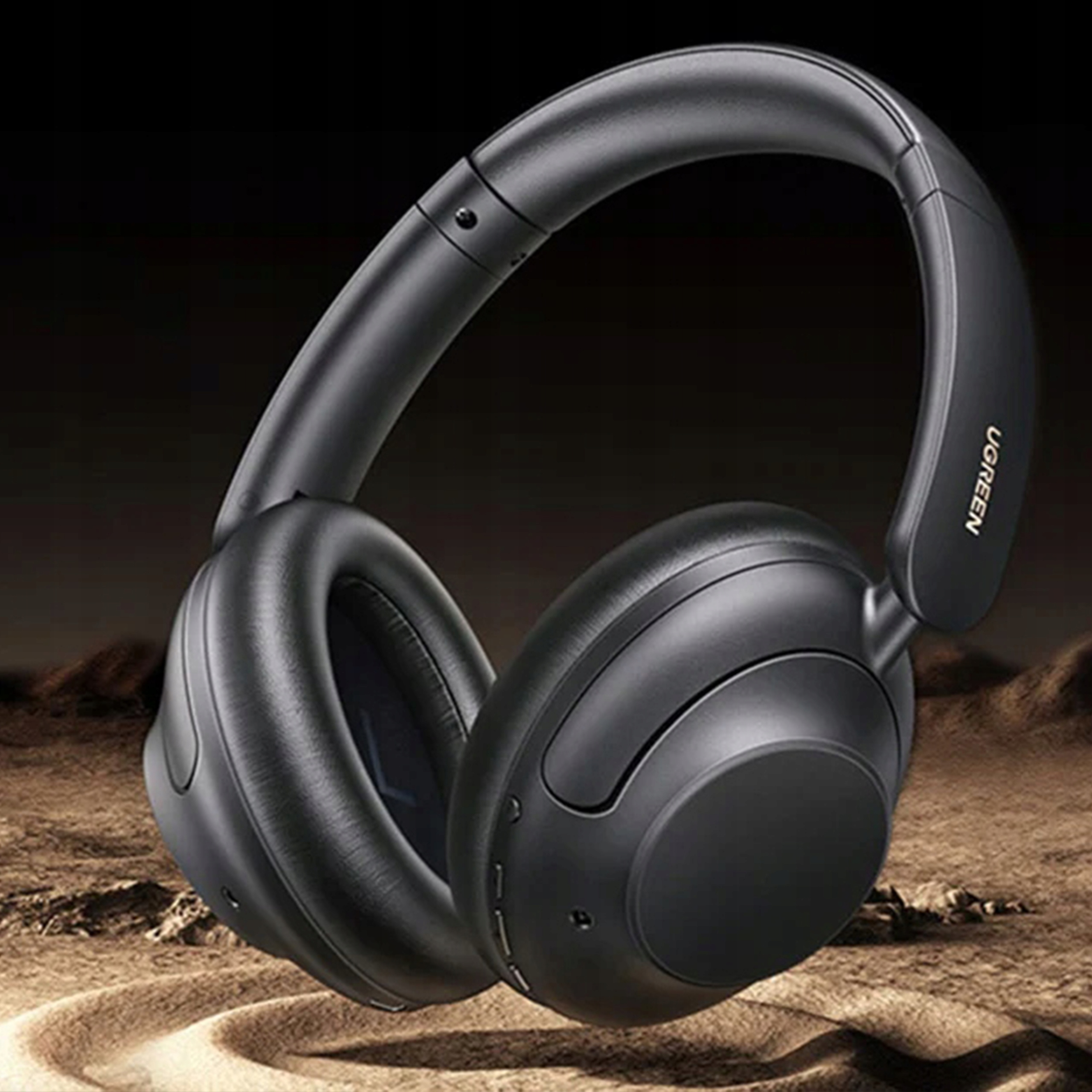 Czarne słuchawki UGREEN na brązowej powierzchni, zbliżenie.