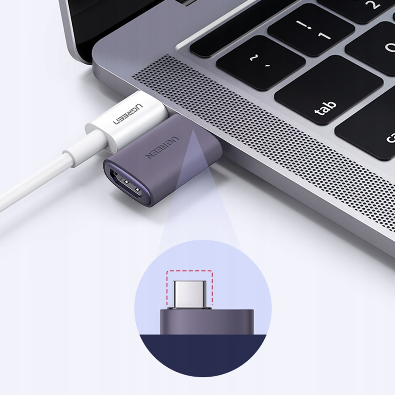 Laptop podłączony do adaptera UGREEN i białego kabla. Adapter jest podłączony do portu USB-C.