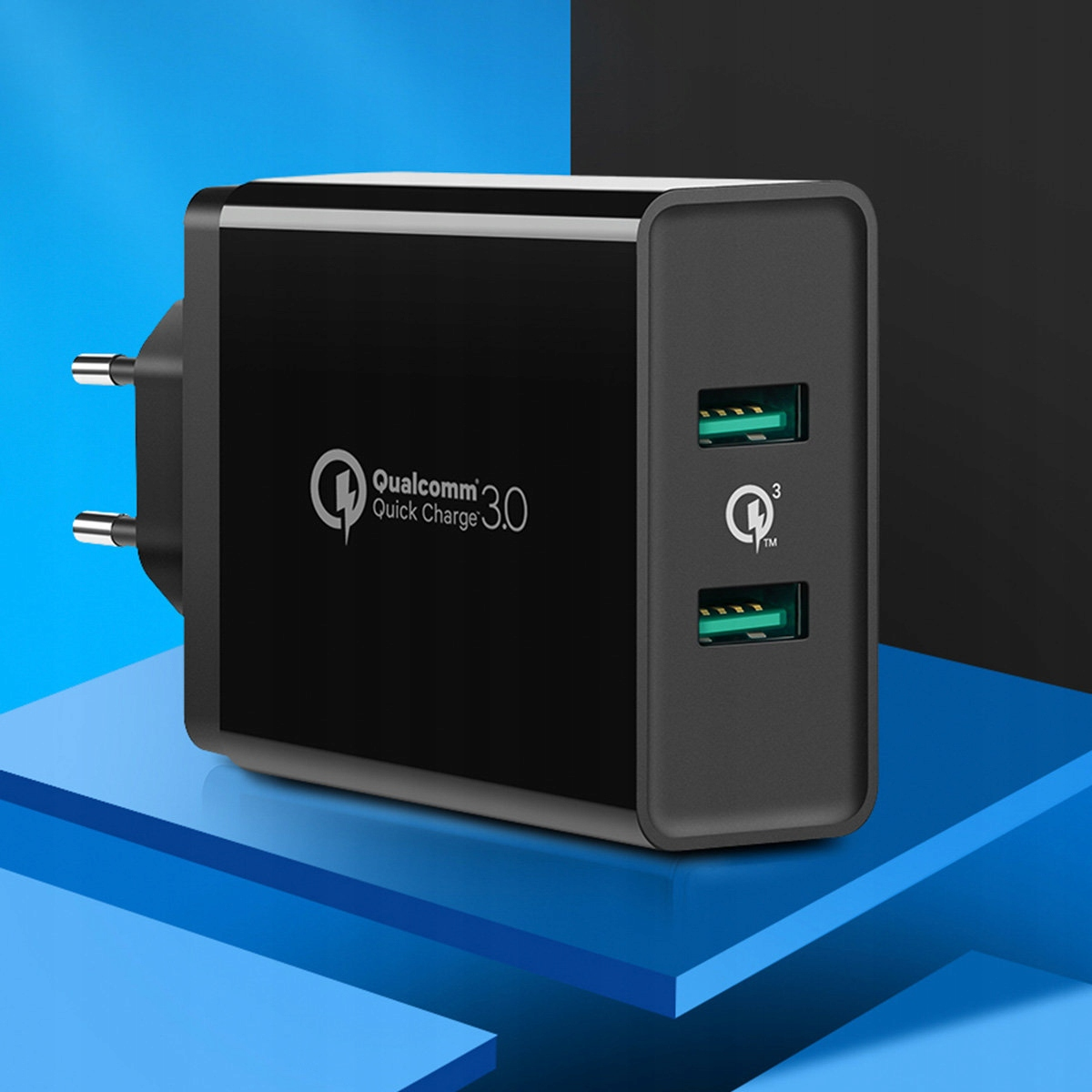 Ein schwarzer Qualcomm Quick Charge 3.0 Netzadapter mit zwei USB-Anschlüssen auf einer blauen Oberfläche.