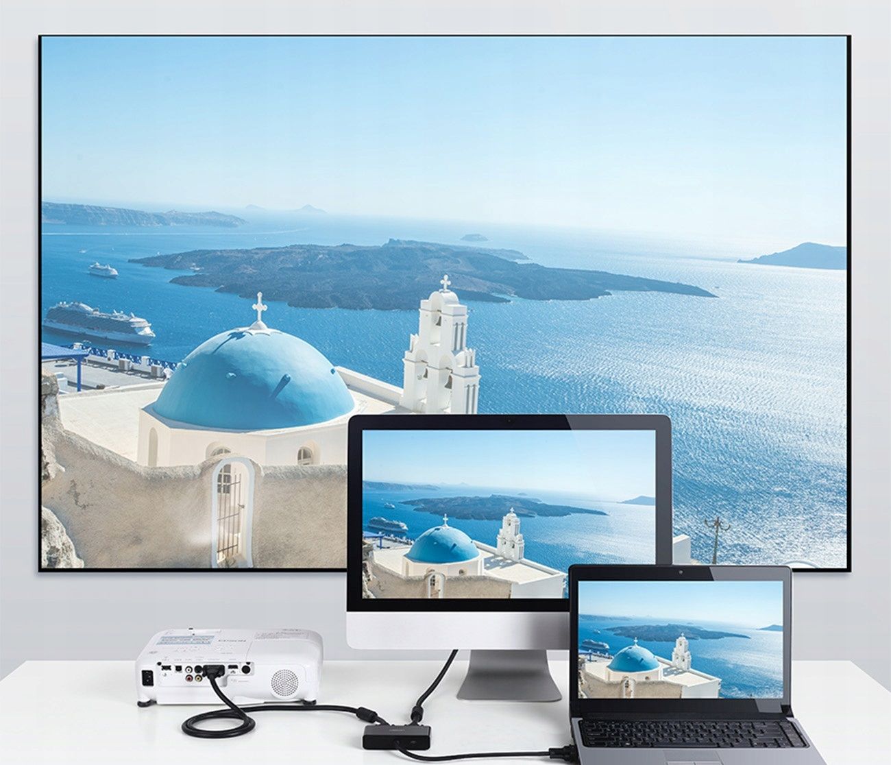 Projektor podłączony do ekranu z wyspą z niebieskimi kopułami i do trzech wyświetlaczy.