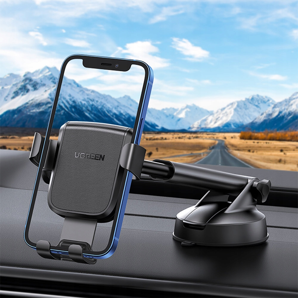 Un smartphone montado en el salpicadero de un coche. El teléfono está en un soporte UGREEN negro.