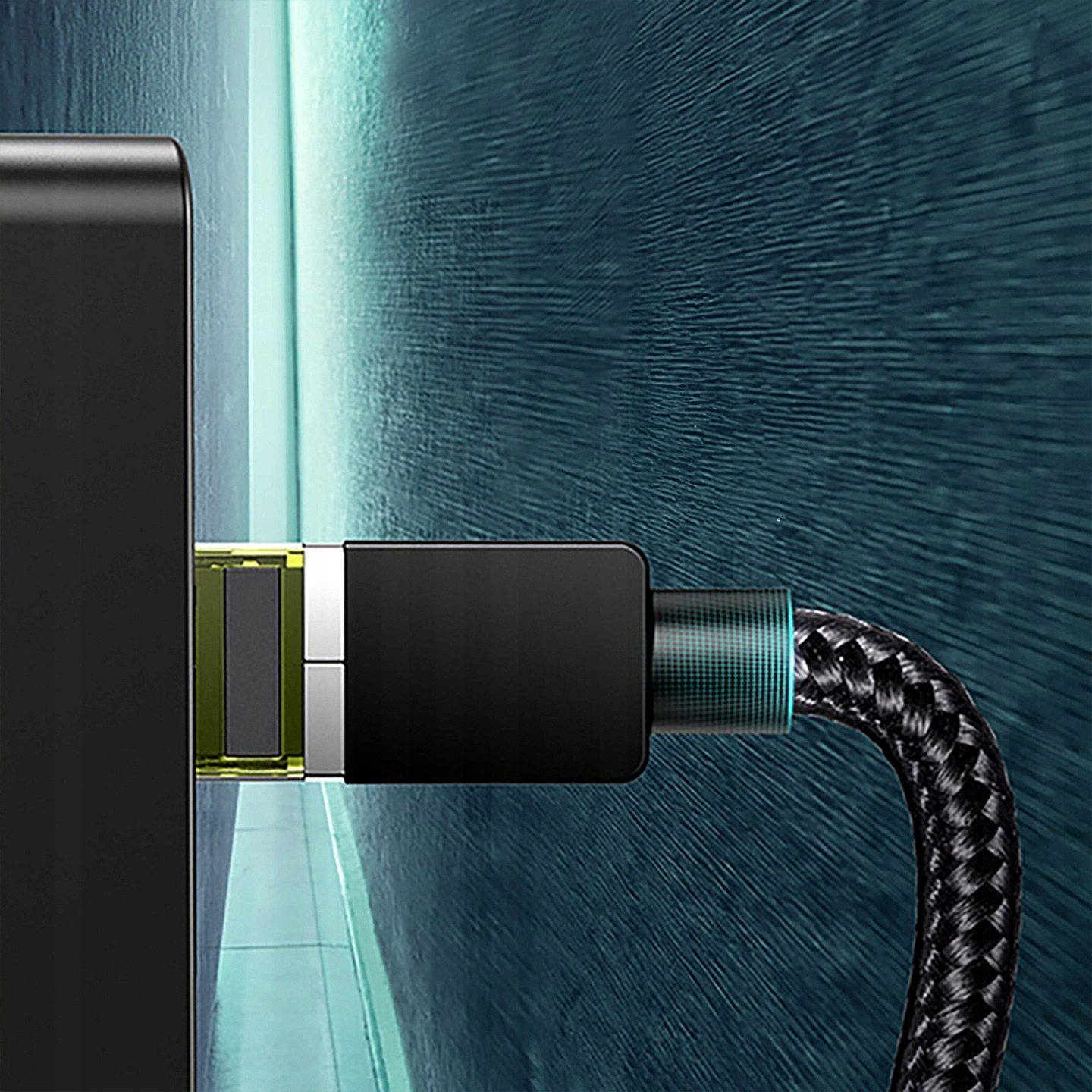 Czarny kabel ładujący podłączony do czarnego urządzenia, z niebieskim tłem.