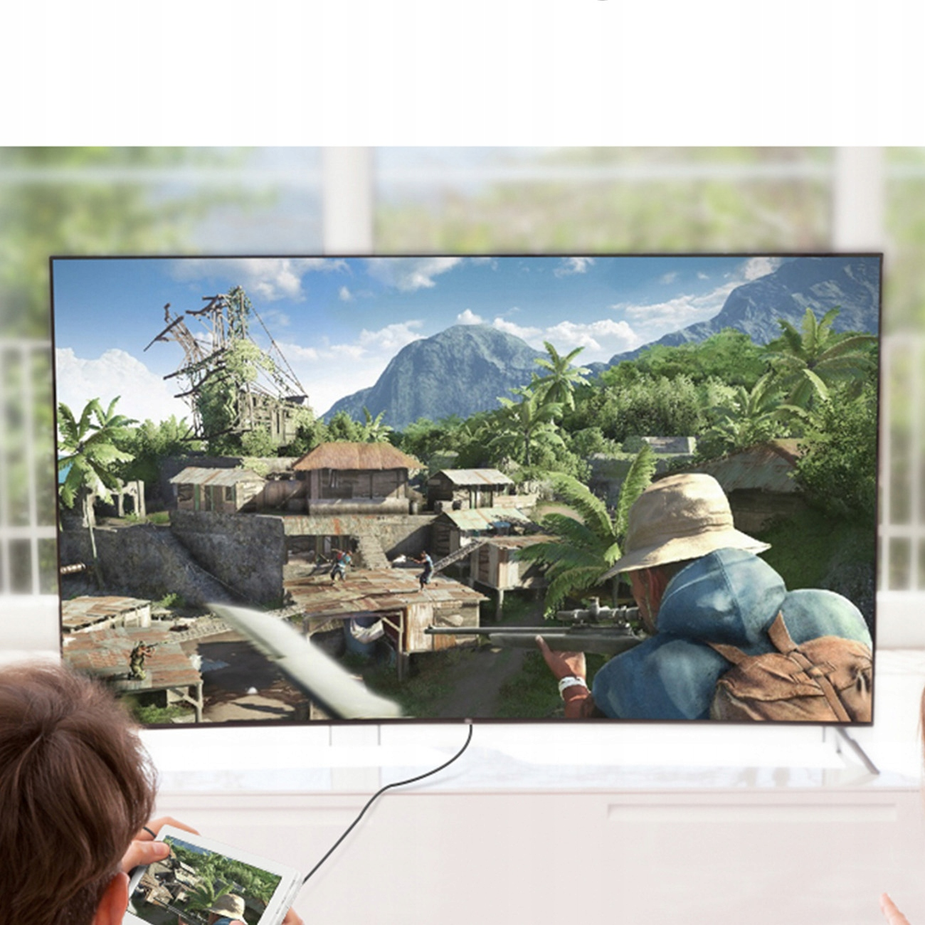 Ekran telewizora wyświetlający grę. Ludzie oglądają. Osoba korzysta z tabletu.