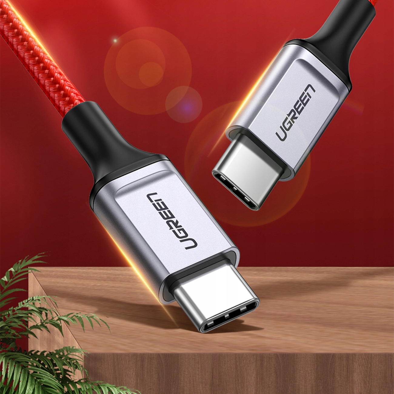 Pokazano dwa złącza USB-C UGREEN. Złącza są srebrne z czarnymi akcentami. Tło jest czerwone.