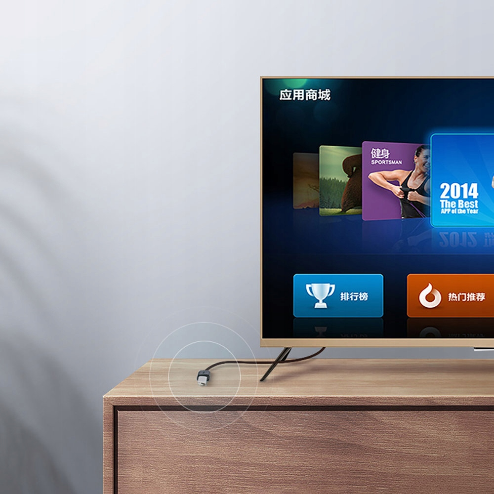 Telewizor wyświetlający sklep z aplikacjami. Kabel jest podłączony do telewizora i umieszczony na drewnianej szafce.