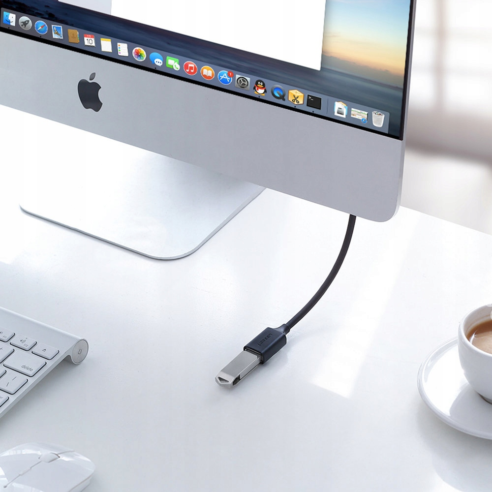 Czarny kabel UGREEN ze złączem USB i USB-C jest podłączony do monitora komputera na biurku.