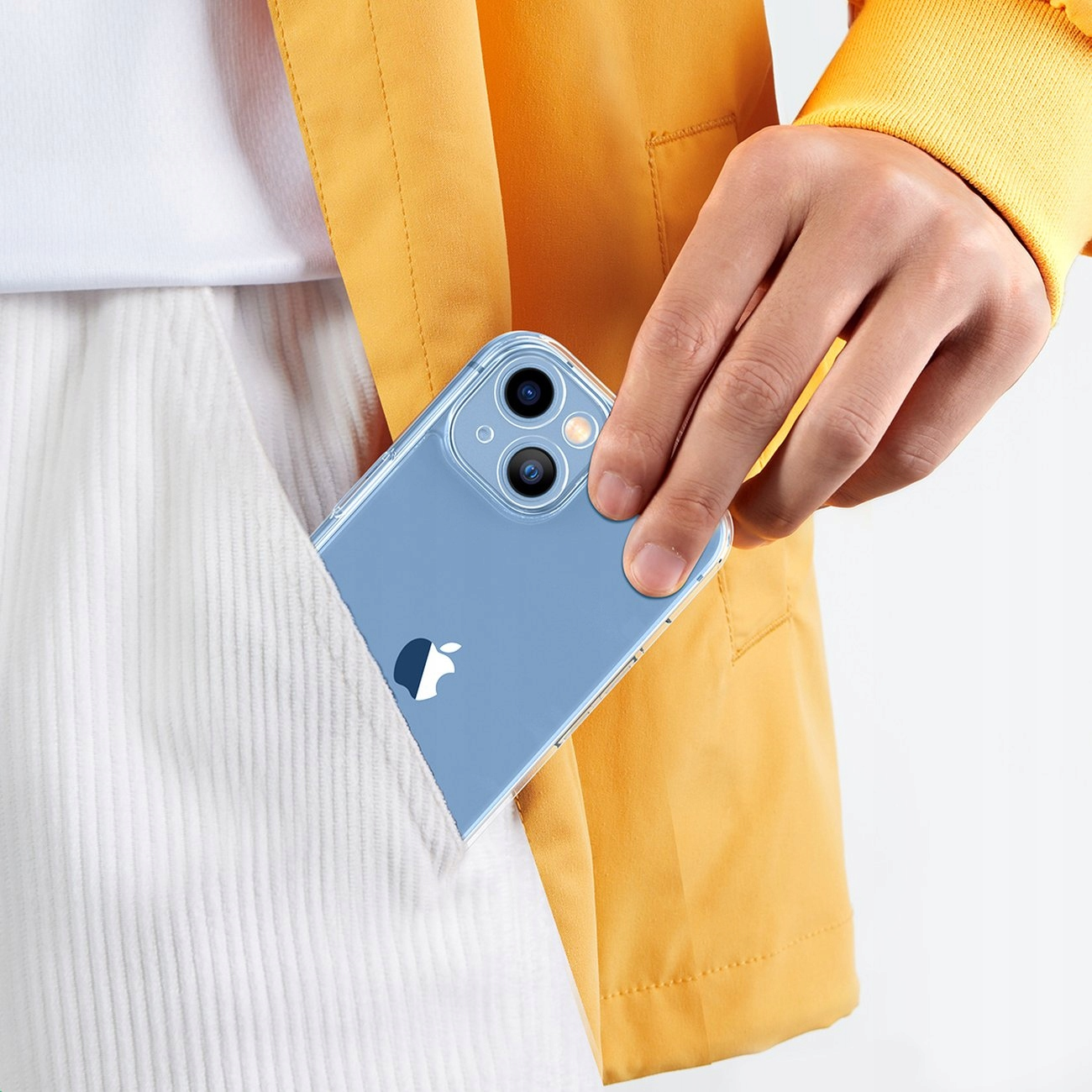 Una mano che tiene un telefono in una custodia in tasca, con una giacca gialla e pantaloncini bianchi.