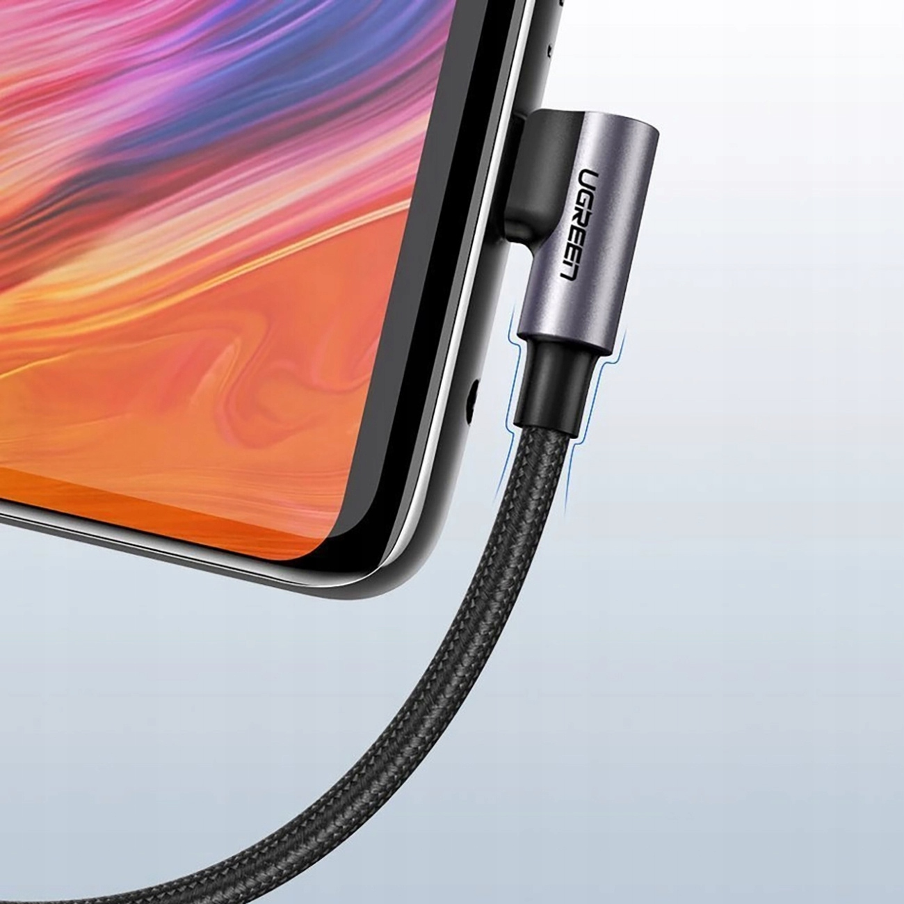 Kabel USB-C do USB podłączony do telefonu. Kabel jest czarny, a złącza srebrne. Widoczne jest logo UGREEN.