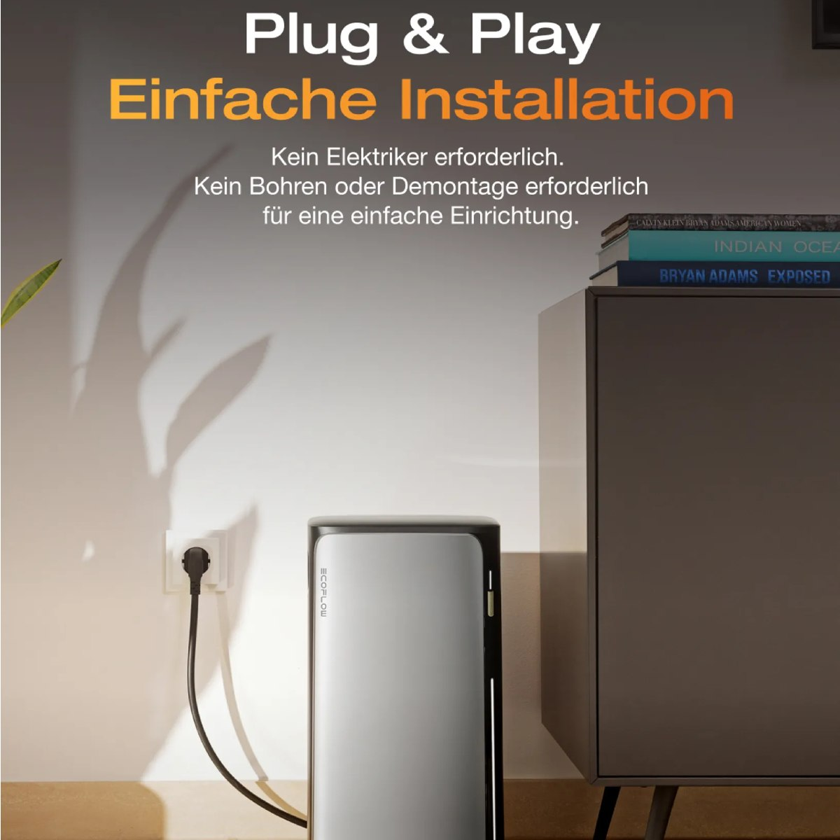 Ein Stromaggregat an einer Steckdose angeschlossen. Ein Schrank und Bücher rechts. Weiße Wand.