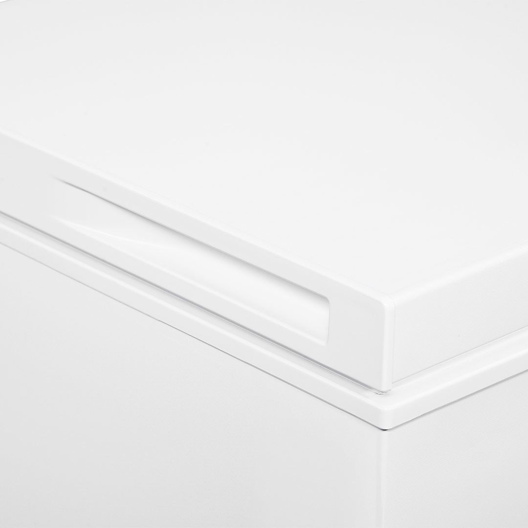 Primer plano de la tapa de un congelador blanco, mostrando el asa y el borde superior.